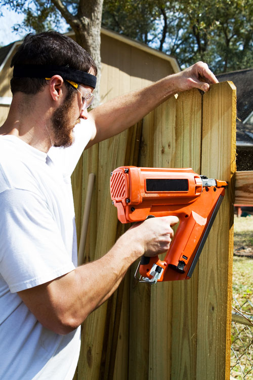 Man installing wood fence in South Florida